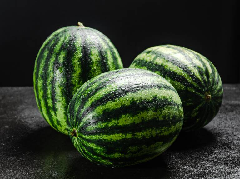 three-fresh-watermelons-with-water-droplets-on-bla-2026-03-09-05-47-24-utc